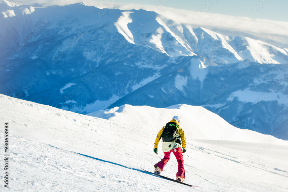 Side view male skier wear colorful outfit isolated on piste ski downhill fast motion in Alps. Active winter holidays, skiing downhill in overcast day. Ski rides on the track with swirls of fresh snow Side view male skier wear colorful outfit isolated on piste ski downhill fast motion in Alps. Active winter holidays, skiing downhill in overcast day. Ski rides on the track with swirls of fresh snow