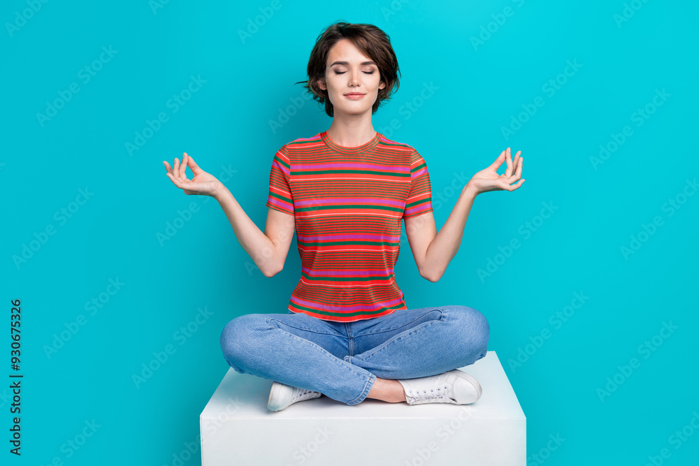 Photo of dreamy adorable cute girl closed eyes sitting on platform meditating yoga isolated on cyan color background Photo of dreamy adorable cute girl closed eyes sitting on platform meditating yoga isolated on cyan color background