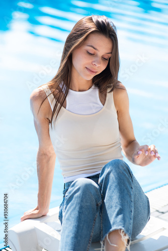 pretty young girl in jeans in the summer pool