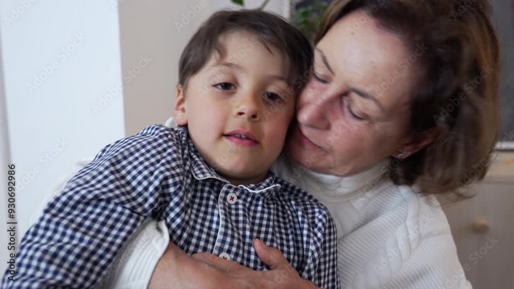 Grandmother gently kissing her grandson on the cheek while holding him close. sharing a quiet and comforting moment, loving family environment Grandmother gently kissing her grandson on the cheek while holding him close. sharing a quiet and comforting moment, loving family environment