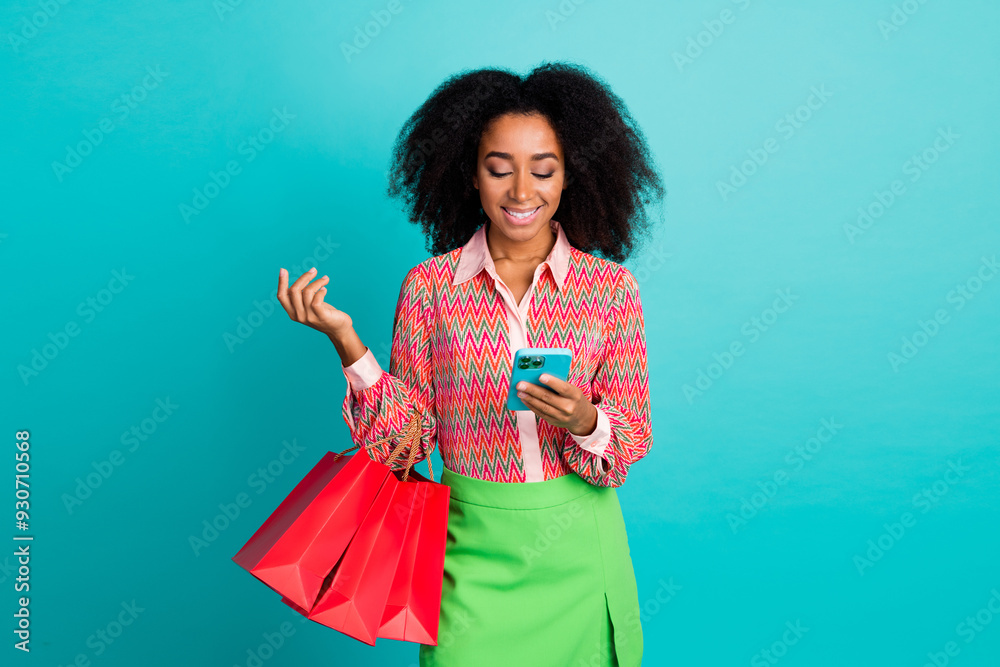 Photo of adorable lovely girl wear print shirt holding shoppers chatting modern device isolated teal color background Photo of adorable lovely girl wear print shirt holding shoppers chatting modern device isolated teal color background