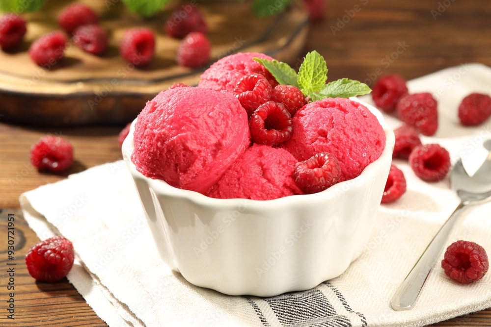 Delicious raspberry sorbet with fresh berries in bowl and spoon on wooden table, closeup Delicious raspberry sorbet with fresh berries in bowl and spoon on wooden table, closeup
