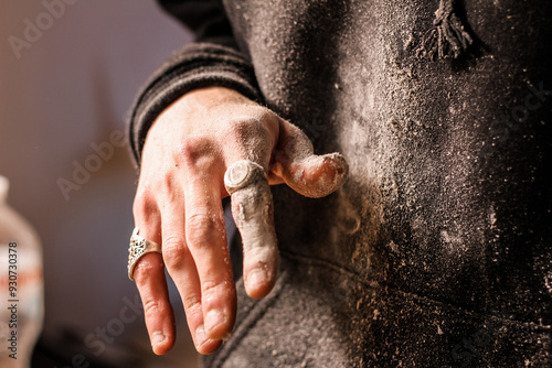Obraz na płótnie Dusty fingers of a woodworker, embellished with ornate rings, demonstrate the blend of artistry and labor in woodworking. w salonie
