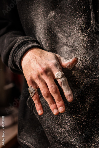 Obraz na płótnie Dust-covered fingers of a skilled woodworker, accentuated by decorative rings, evoke the rugged beauty of manual craftsmanship. Vertical photo w salonie