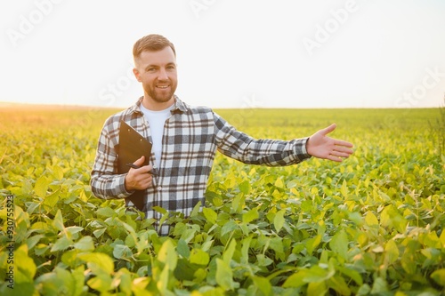 Farmer standing in soybean field at sunset