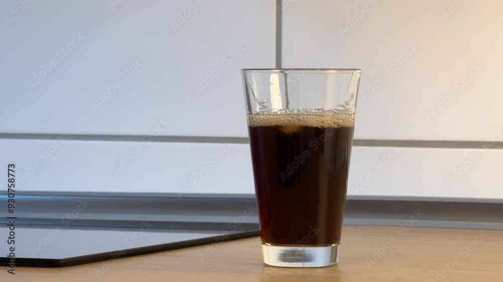 fast filling a glass with cold cola or other dark colored foamy drink fast filling a glass with cold cola or other dark colored foamy drink