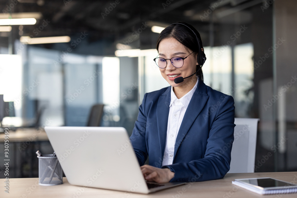 Asian businesswoman with headset using laptop in modern office. Professional and engaged in task with focus on technology. Asian businesswoman with headset using laptop in modern office. Professional and engaged in task with focus on technology.