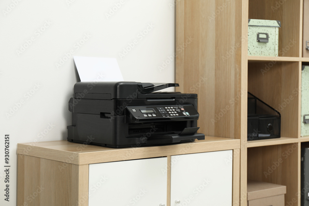 Modern printer with paper on wooden nightstand in office Modern printer with paper on wooden nightstand in office
