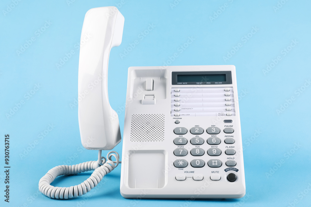 White telephone with handset on light blue background White telephone with handset on light blue background