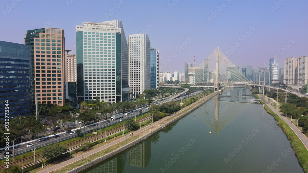 Vista dos prédios comerciais ao longo da Marginal Pinheiros, com a imponente Ponte Estaiada ao fundo, destacando a arquitetura moderna e a infraestrutura de São Paulo Vista dos prédios comerciais ao longo da Marginal Pinheiros, com a imponente Ponte Estaiada ao fundo, destacando a arquitetura moderna e a infraestrutura de São Paulo