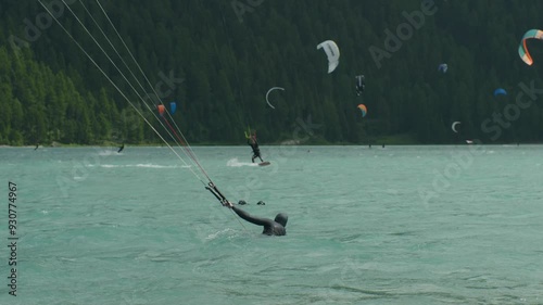 Kiteboarding on the Silvaplanersee in Engadin, Switzerland. Lots of Kiteboarders showing their tricks on a summer day nearby Sankt Moritz. photo