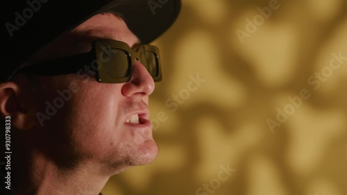 Close up of rap artist singing for a music video on a warm textured background