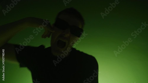 Close up of rap artist singing for a music video on a color changing background