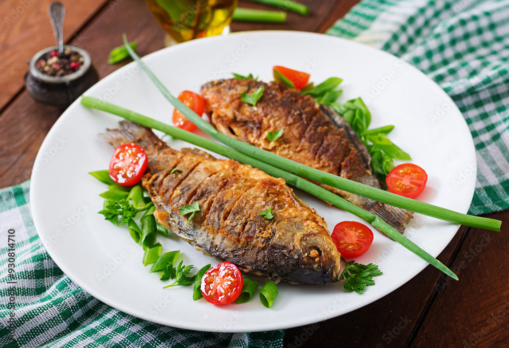 Fried fish carp and fresh vegetable salad on wooden background. Fried fish carp and fresh vegetable salad on wooden background.