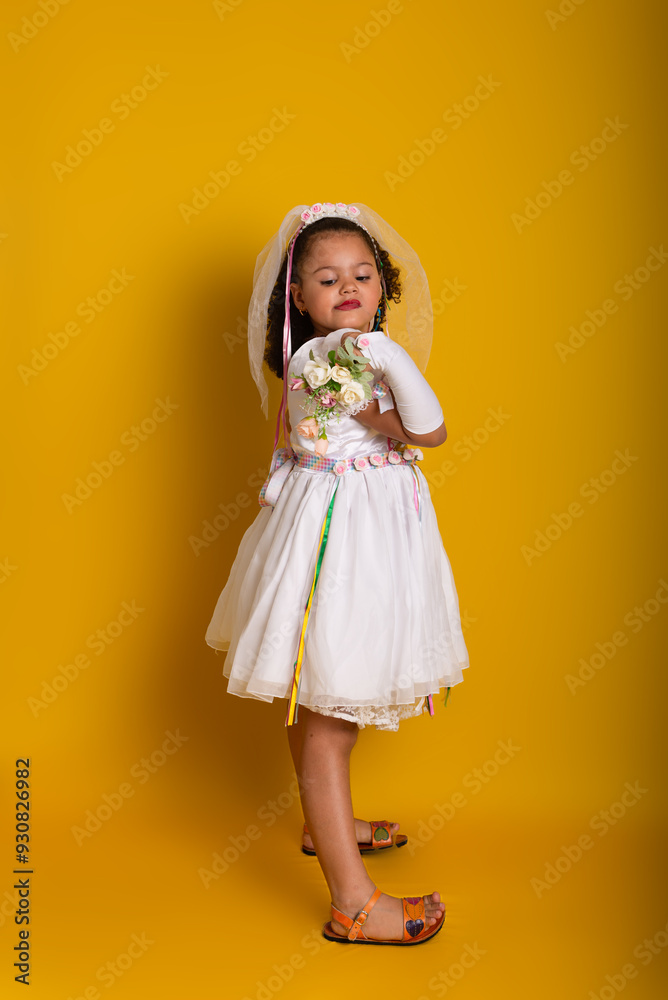Cheerful child dressed as a bride holding a bouquet of flowers and posing for the camera. Cheerful child dressed as a bride holding a bouquet of flowers and posing for the camera.