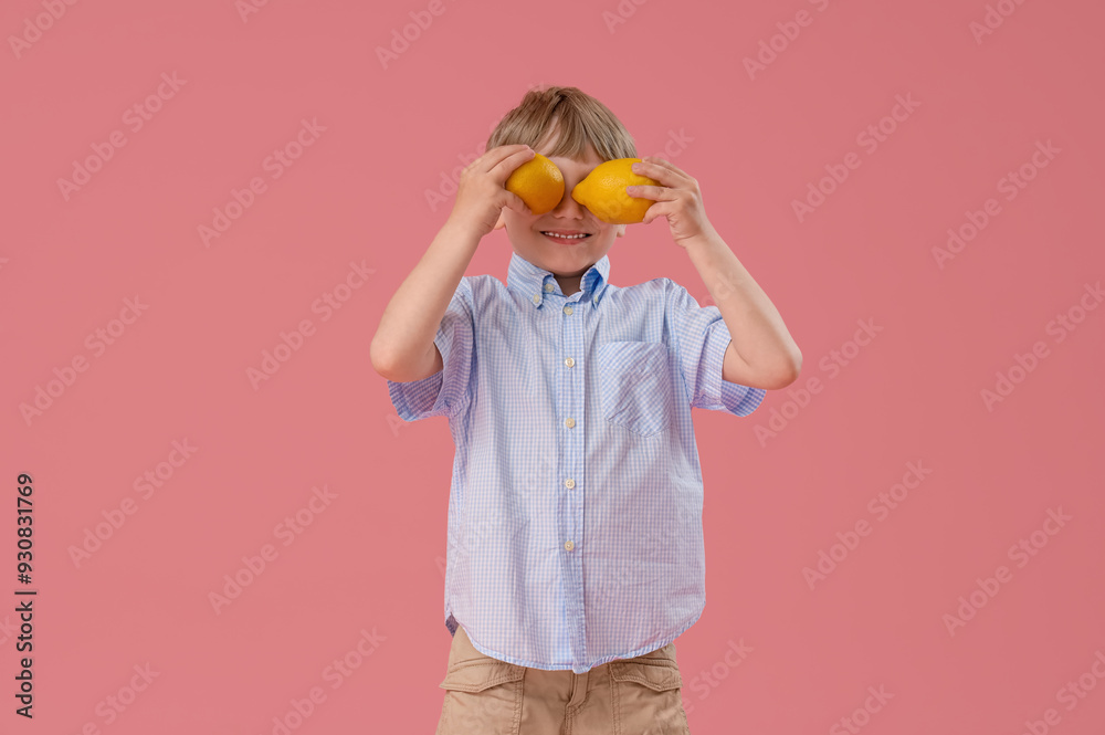 Cute little boy with lemons on pink background Cute little boy with lemons on pink background