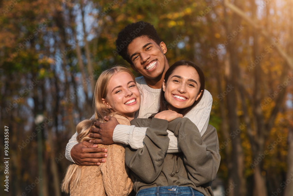 African guy hugging his pretty international girlfriends, walking by park and posing African guy hugging his pretty international girlfriends, walking by park and posing