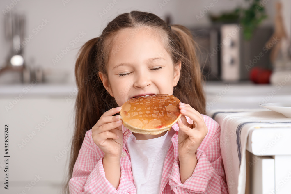 Cute little girl eating pancake with honey in kitchen, closeup Cute little girl eating pancake with honey in kitchen, closeup