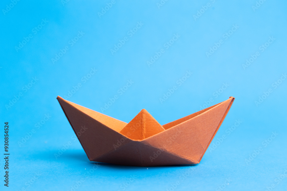 orange paper boat on blue background, concept for leadership, teamwork and winning success orange paper boat on blue background, concept for leadership, teamwork and winning success