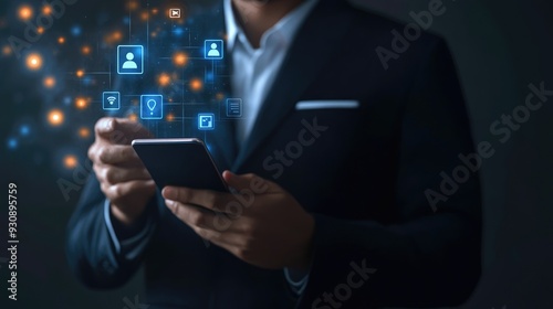 Wallpaper Mural Businessman in a sleek suit, holding a smartphone with floating app icons, symbolizing connectivity and innovation in business. Vibrant digital interface overlay. Torontodigital.ca
