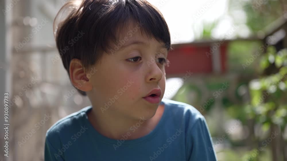 Young boy looking intently to the side, with a thoughtful expression on a sunny day. the quiet moment of a child lost in thought, surrounded by the greenery of the outdoors Young boy looking intently to the side, with a thoughtful expression on a sunny day. the quiet moment of a child lost in thought, surrounded by the greenery of the outdoors