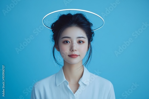 Portrait of a serene woman with a glowing halo set against a solid blue background representing purity mental clarity and spiritual peace in a minimalist and tranquil composition