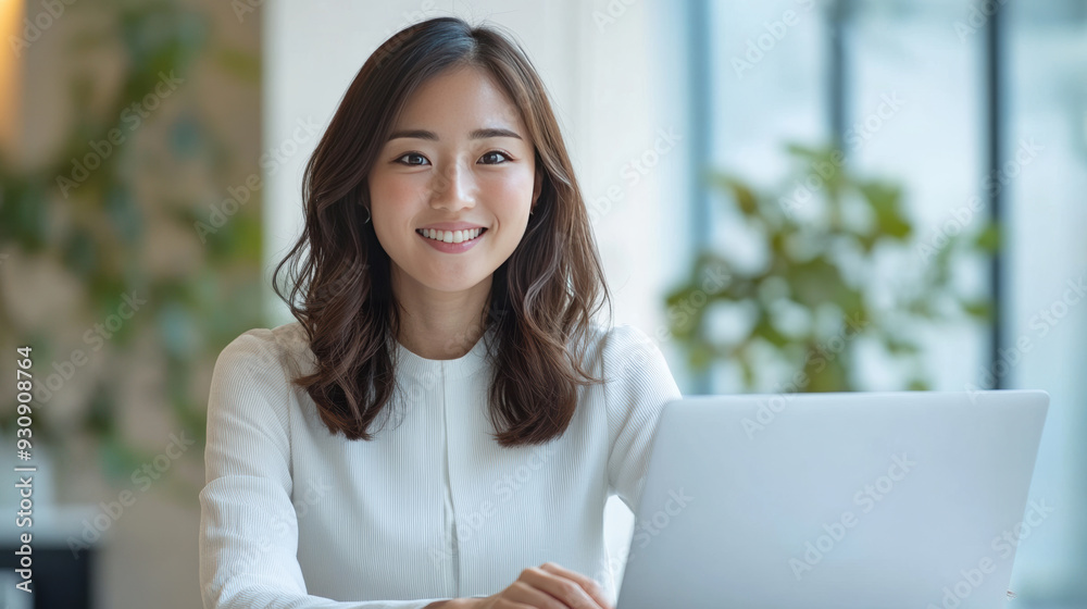 Asian woman seated at her desk, working on her laptop, exemplifying the modern small business owner and freelance professional. Asian woman seated at her desk, working on her laptop, exemplifying the modern small business owner and freelance professional.