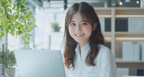 Asian woman seated at her desk, working on her laptop, exemplifying the modern small business owner and freelance professional.