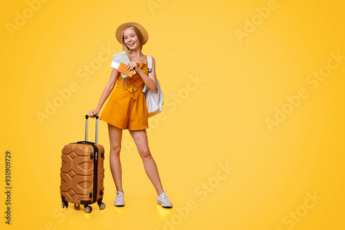 Ready For Summer Vacation. Young Tourist Girl Posing With Travel Suitcase And Tickets Over Yellow Background