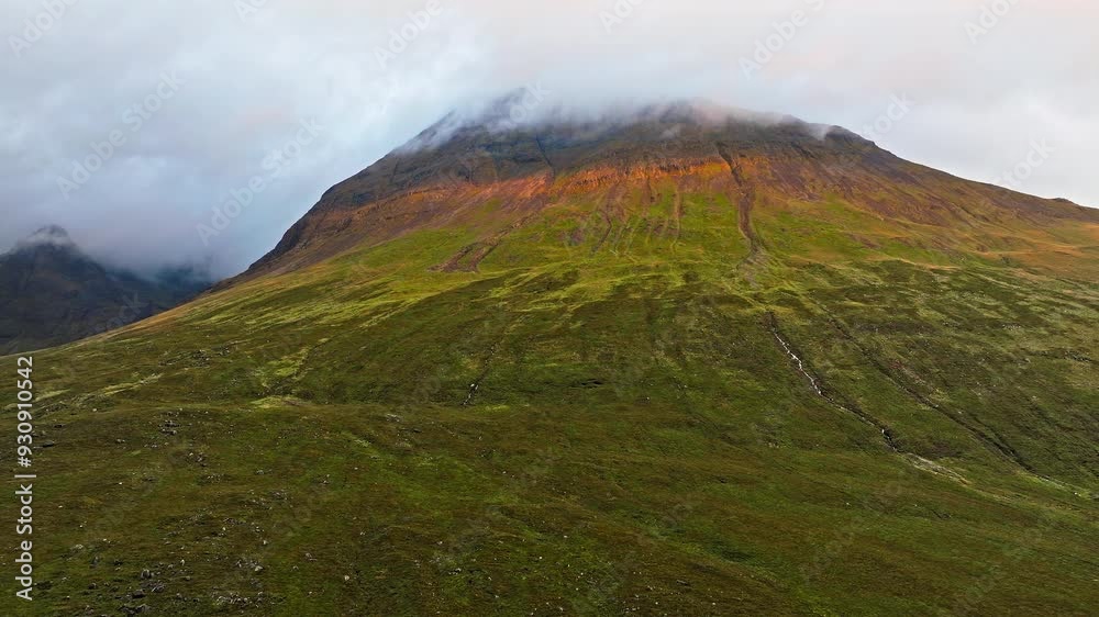 Scenic view of sunset over a high mountain in the Isle of Skye. Scottish Mountain peak, geological formation on the Highlands of Scotland, United Kingdom. Scenic view of sunset over a high mountain in the Isle of Skye. Scottish Mountain peak, geological formation on the Highlands of Scotland, United Kingdom.