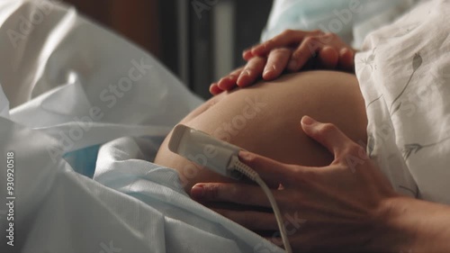 Pregnant mother at hospital holding her stomach right before giving birth