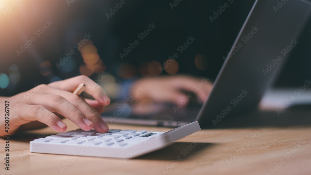 Businessman using a calculator to calculate numbers ,profit and loss statement review of company performance , effective tax deduction planning for individuals and companies paying tax rates