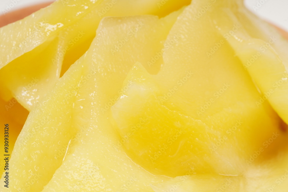 Young mango kickshaw, made from thinly sliced tangy yellow mango, placed on a wooden dish, photographed with a white background. Young mango kickshaw, made from thinly sliced tangy yellow mango, placed on a wooden dish, photographed with a white background.