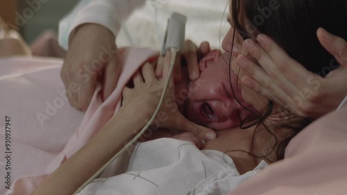 Mother holding her newborn in the hospital who is crying