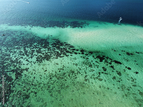 Aerial view of the coral reef on the Koh Lipe island, the sea has different shades of blue due to the coral, the white sand and the depth which creates beautiful patterns photo