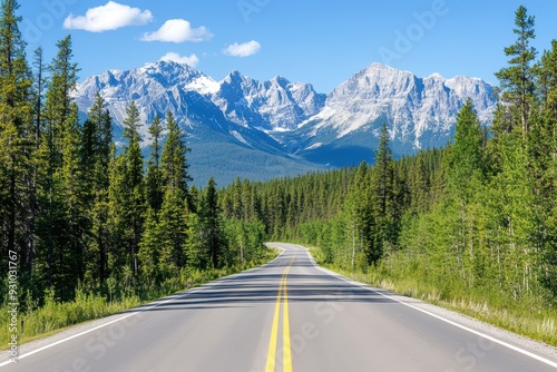 A scenic highway surrounded by lush trees and majestic mountains under a clear blue sky, perfect for travel and adventure.