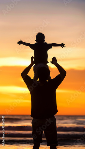 Silhouette of a father holding his son on his shoulders at sunset