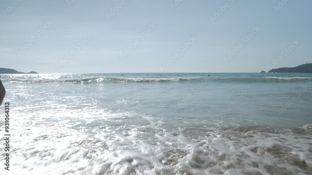 natural landscape over the sea beach surface in sunny afternoon time with sea wave hits white sand beach and people enjoying relax swimming in the sea. white sand beach natural view. natural landscape over the sea beach surface in sunny afternoon time with sea wave hits white sand beach and people enjoying relax swimming in the sea. white sand beach natural view.