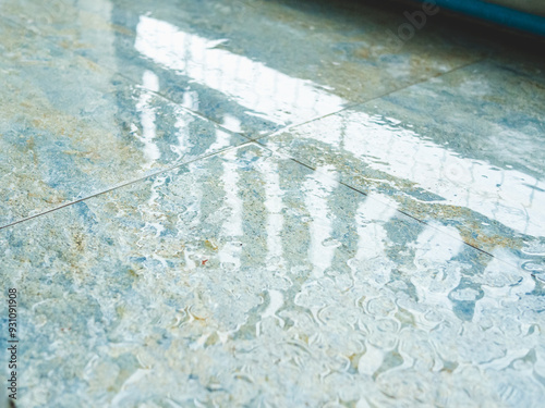 Wet surface on floor with water pooling from rainwater. photo