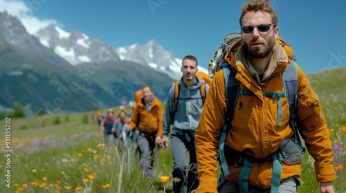 A photography of a group of hikers with snow-capped peaks in the background