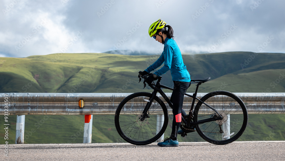 Cyclist with road bike on grassland mountain top trail Cyclist with road bike on grassland mountain top trail