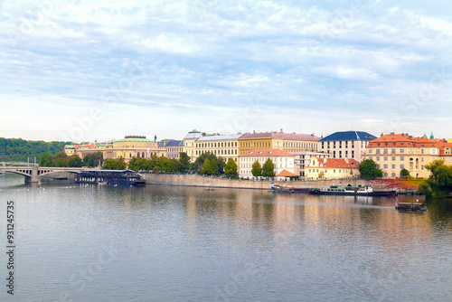 A scenic view of the riverside in Prague. Historic buildings along the water. Vltava River. Prague, Czech Republic.