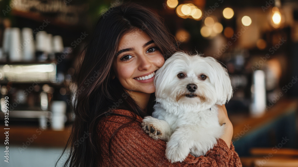 Charming woman with long hair, holding her fluffy white dog in a trendy coffee shop, smiling Charming woman with long hair, holding her fluffy white dog in a trendy coffee shop, smiling
