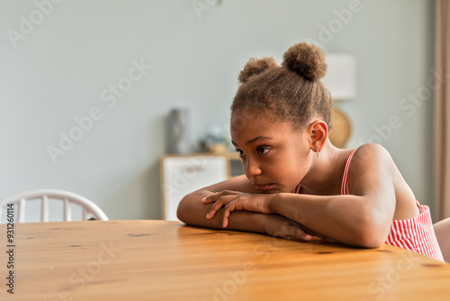 African American girls sitting at table feeling sad and upset photo