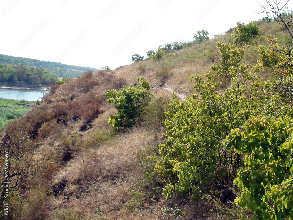 Panorama of the top of a rocky Dnieper hill covered with a blanket of steppe vegetation through which a narrow strip of mountain path winds. Panorama of the top of a rocky Dnieper hill covered with a blanket of steppe vegetation through which a narrow strip of mountain path winds.