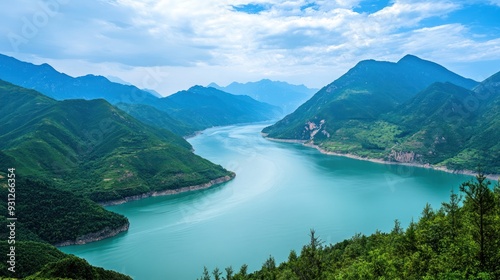 Serene turquoise lake nestled between lush green mountains under a partly cloudy sky.