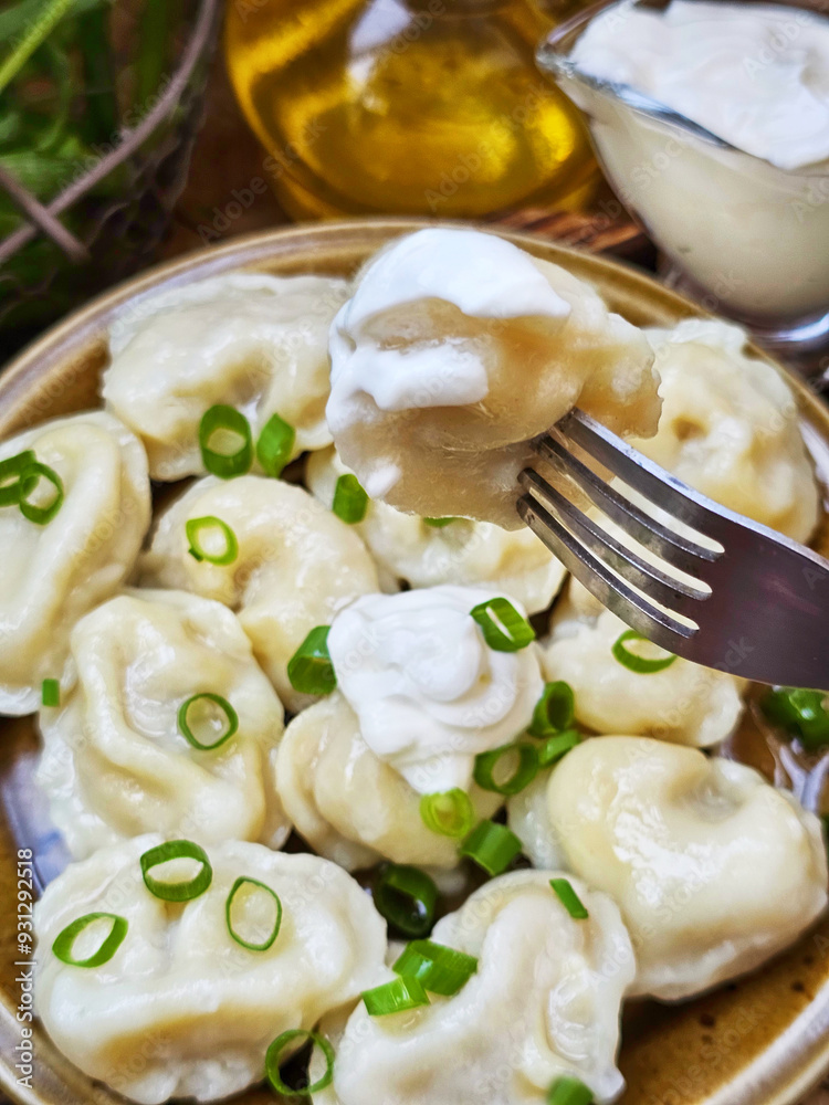 Dumplings with sour cream on a wooden table Dumplings with sour cream on a wooden table