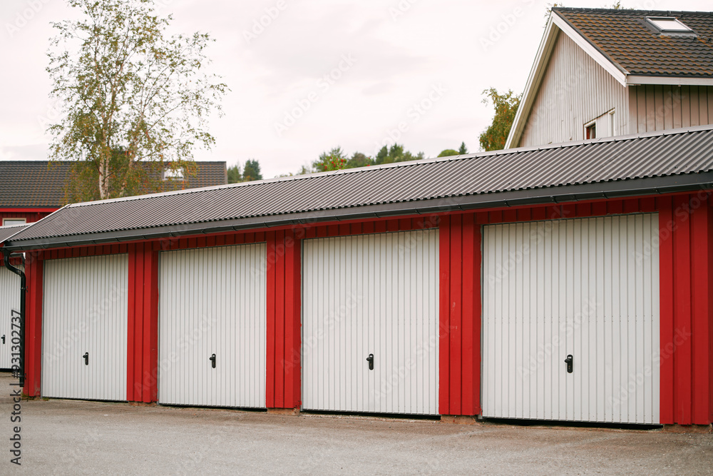 Red garage units with white doors in a suburban area Red garage units with white doors in a suburban area