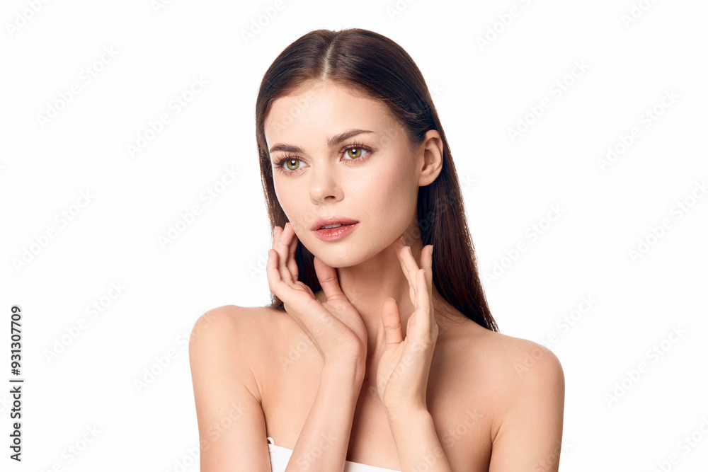 Beautiful young woman posing with her hands on her face against a white background Beautiful young woman posing with her hands on her face against a white background