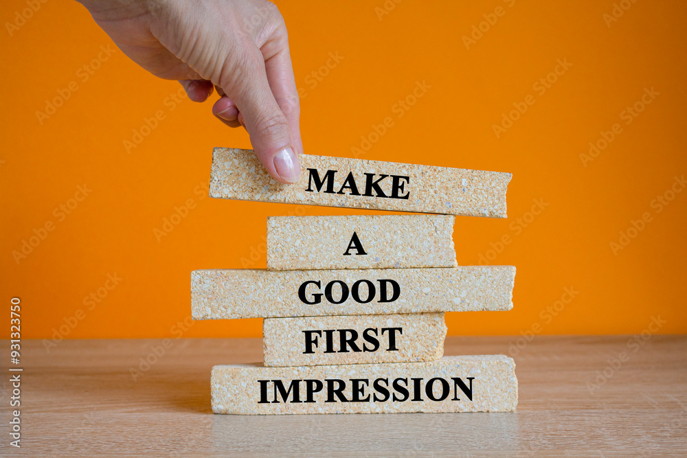 Concept words Make A Good First Impression on brick blocks. Beautiful wooden table orange background. Businessman hand. Business legacy and future concept.